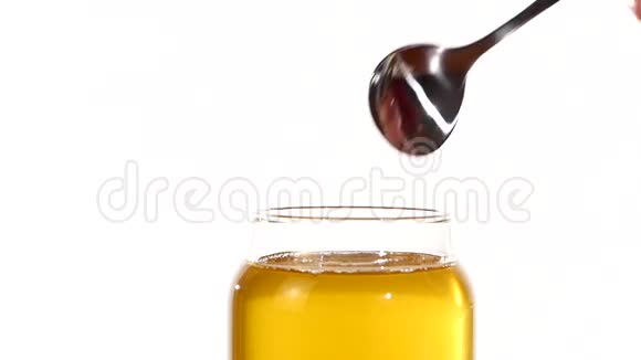 用金属勺子从玻璃瓶中取出蜂蜜视频的预览图
