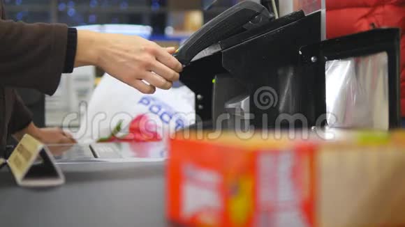 顾客在结帐时支付产品费用超市传送带上的食物带收银机和终端机的现金台视频的预览图