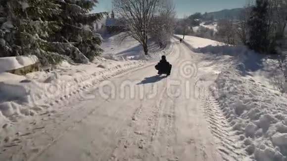 年轻的幸福家庭在雪林里玩得很开心父亲把他的小儿子卷在雪橇上爸爸和他的小儿子视频的预览图