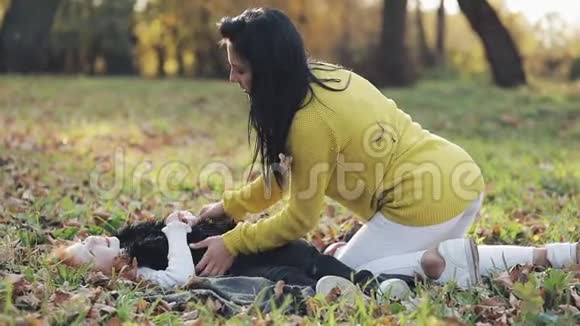 快乐的年轻母亲和她的小红发女儿在秋天的公园里玩得很开心他们玩着笑着慢动作视频的预览图