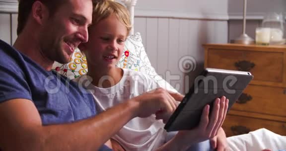 父子看着床上的数码平板视频的预览图