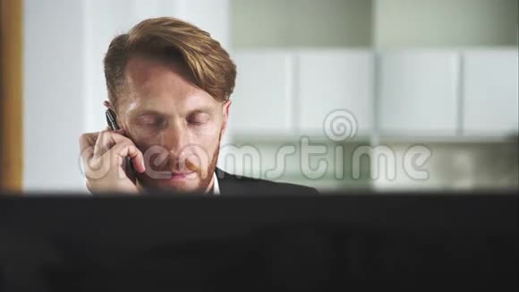 红发男子坐在电脑前打电话视频的预览图