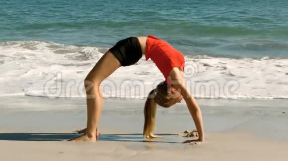 在海滩上练习体操的女人视频的预览图