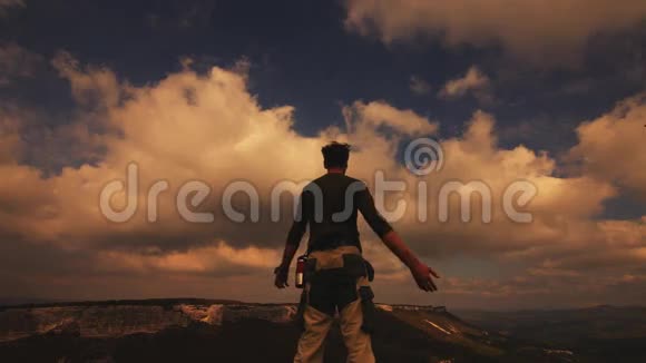 徒步旅行者背着背包在山顶放松享受日出视频的预览图