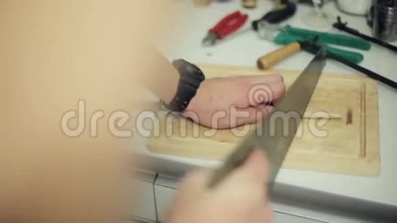 人用锯子在木厨房板上剪鼓棍烹饪音乐视频的预览图