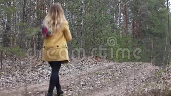在森林的绿色柏油路上行走的女人视频的预览图