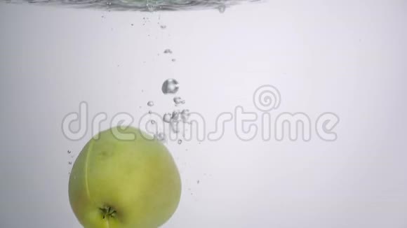 一半的苹果掉在白色背景的水里视频的预览图