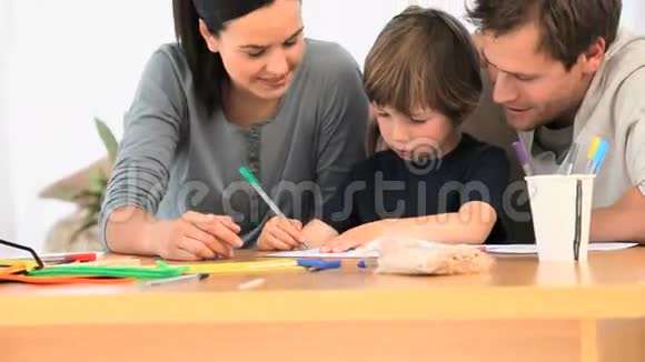 父母看着他们可爱的儿子画画视频的预览图