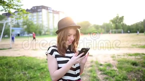 戴帽子的可爱女孩拿着手机视频的预览图