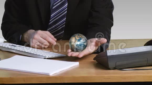 一位手握旋转地球仪的商人视频的预览图