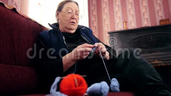 家里的老太太在沙发上编织羊毛袜子视频的预览图