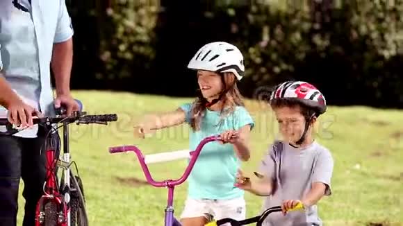 父母和孩子在骑自行车时指着路视频的预览图