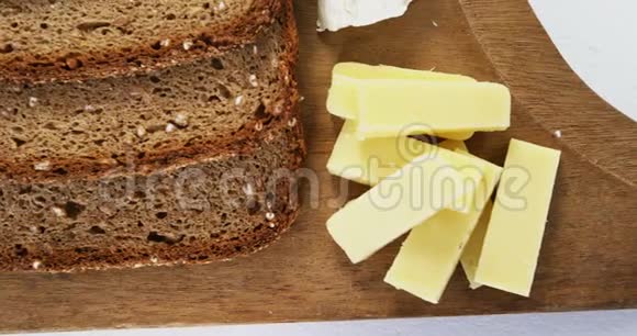 木板上有各种奶酪和棕色面包视频的预览图