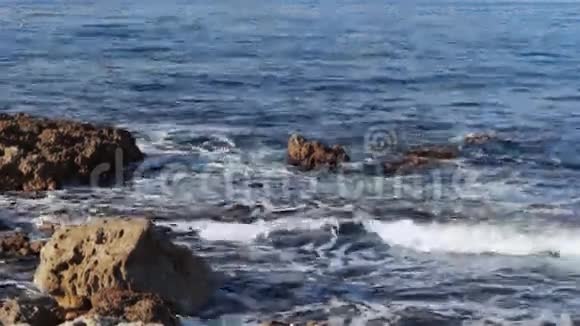 海浪轻轻拍打着岩滩视频的预览图