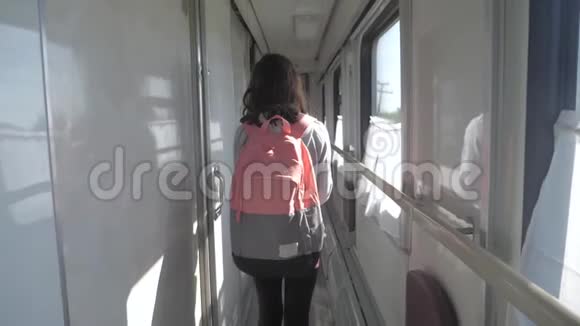 十几岁的女孩带着背包在火车车厢里散步交通运输铁路概念小女孩走路视频的预览图