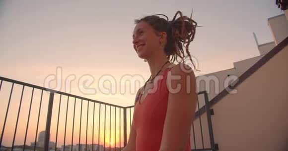 精神白种人女性的特写肖像带着可怕的人在屋顶冥想背景是美丽的日落视频的预览图