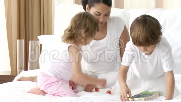 父母在卧室里和孩子玩玩具方块视频的预览图