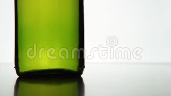 帽子落在绿色瓶子附近白色背景视频的预览图