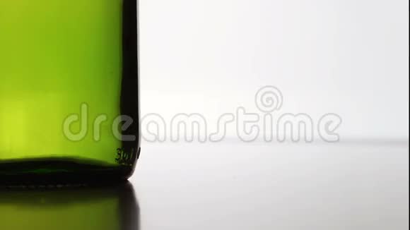 一顶帽子掉在白色背景上的绿色瓶子附近视频的预览图