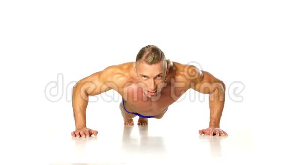 英俊的肌肉男在白色上做俯卧撑视频的预览图