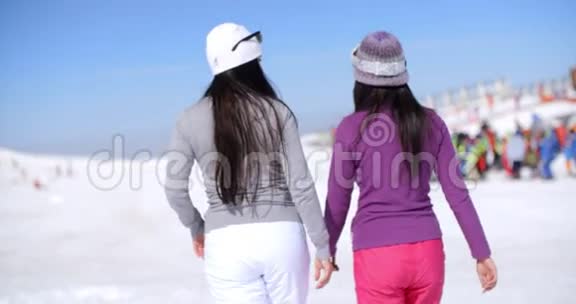 两个年轻女子在冬季滑雪场散步视频的预览图
