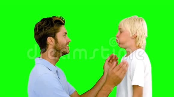 男人用绿色屏幕压着儿子鼓鼓的脸颊视频的预览图
