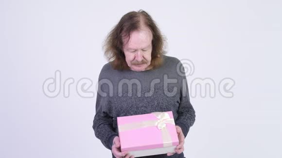 快乐的老人微笑着拿着礼品盒视频的预览图