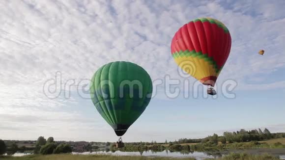 热气球飞过湖面和田野视频的预览图