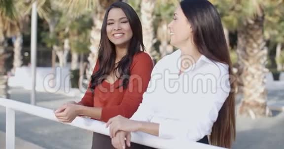 在热带城市公园里聊天的年轻妇女视频的预览图