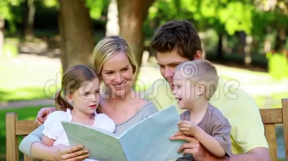 一家人在长凳上看图画书视频的预览图
