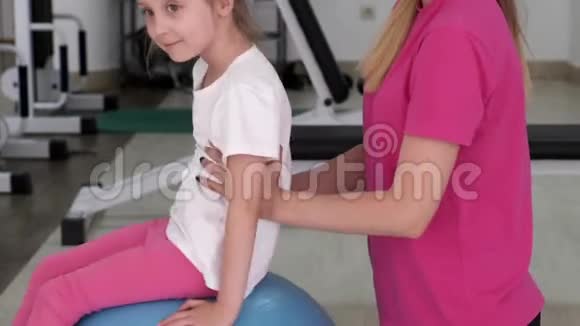 教练在健身房和一个小女孩一起工作视频的预览图