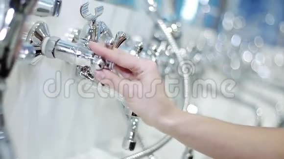 女人的手在浴池里转动水龙头抛光铝阀视频的预览图