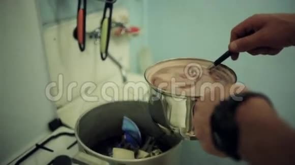 人的手把红色的团块倒入带有不可食用物体的平底锅中艺术屋厨师视频的预览图