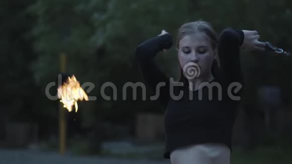金发自信的女人在森林或公园里用火焰表演节目的肖像有技巧的消防艺术家视频的预览图