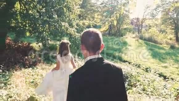 英俊的新郎来到公园里的新娘慢慢地视频的预览图