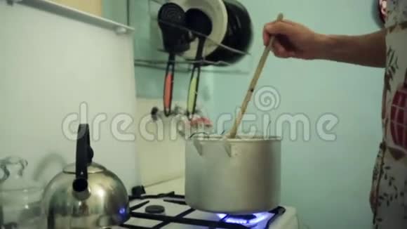 人用木棍在煤气炉上用煮锅拌丝艺术之家视频的预览图
