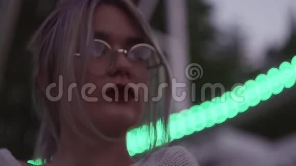 美丽的金发女孩戴着圆形眼镜在游乐园里视频的预览图