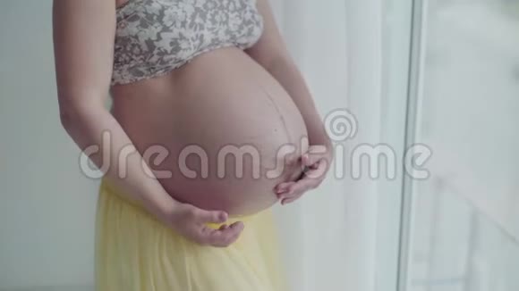 怀着肚子的美丽孕妇女人摸她的肚子回家的准妈妈视频的预览图