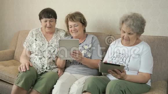 老年妇女用数码平板电脑看照片视频的预览图