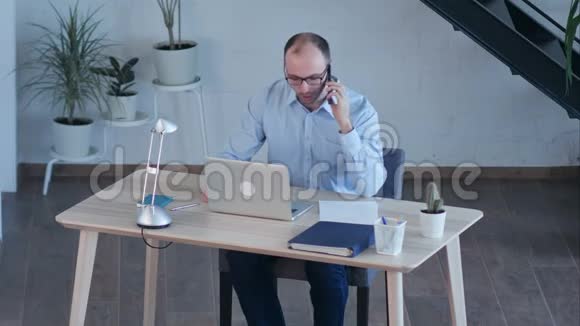 3商人在讲智能手机的时候总是在电脑上工作视频的预览图