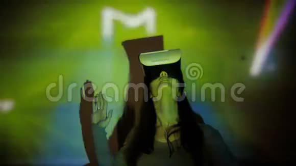 女人在聚光灯下使用VR头盔视频的预览图