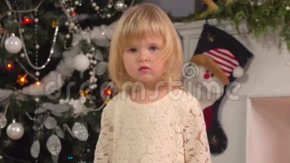 小女孩在圣诞树旁微笑视频的预览图