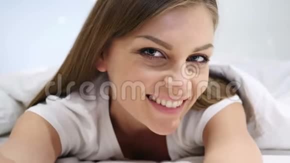 美丽的女人躺在床上微笑着看着镜头视频的预览图