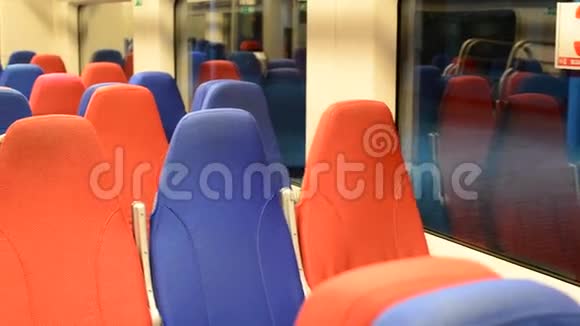 一辆空火车的内部有红色和蓝色的座位视频的预览图