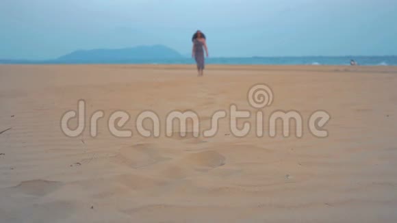 小女孩正沿着海滩散步击中了腿视频的预览图