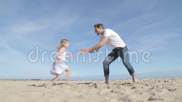 父亲在海滩上旋转女儿视频的预览图
