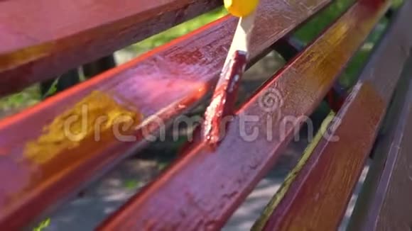 用红色的画笔用黄色的保护手套用近距离的手画木板视频的预览图