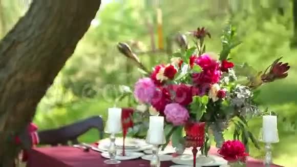 婚礼桌装饰与吊烛装饰与精致的花在外举行婚礼视频的预览图