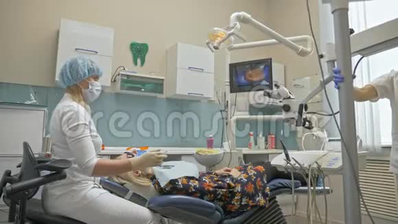 医生用特殊的口腔内数字微相机检查牙齿在监视器上牙医和病人看到牙齿的视频视频的预览图