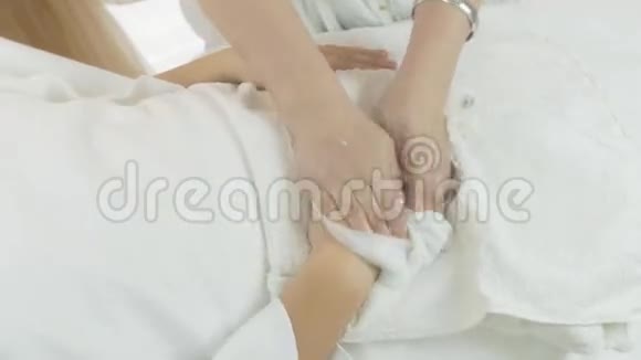 美容师在美容院用餐巾纸擦拭成年女性的双手视频的预览图